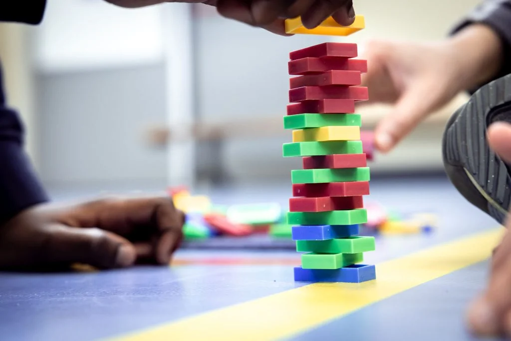 Kinderen bouwen samen een toren van gekleurde blokken